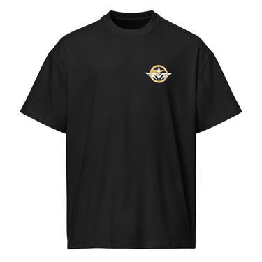 Front view of a box tee in Black. A small circular emblem sits on the left chest: a gold ring lettered "MIRACULUM IN CAELO NUMQUAM CADET" in white capitals, with a white winged spearhead standing through its centre and swept wings running out to either side.