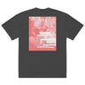 Back view of a oversized tee in faded black. A large coral pink poster panel fills the upper back, printed with a stylized winged figure in soft tonal linework set against a bank of clouds. Horizontal white bars redact most of the text, leaving the words "she, who silences the ether" legible between them, with faint handwritten script and a small circular seal layered underneath. An expressive, editorial, graphic-forward composition.