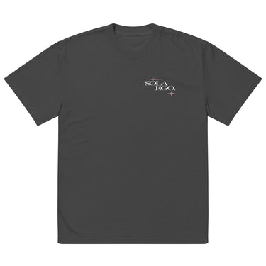 Front view of an oversized tee in faded black. A small left-chest graphic reads 'SOLA EGO' in a high-contrast serif, split across two lines, with two four-pointed star accents in dusty pink flanking the type.