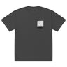 Front view of an oversized tee in faded black. A small halftoned panel sits on the left chest: a bare, leafless tree standing over dark undergrowth, printed with a woven fabric texture and rough torn edges. Below it the words "pas seul" are set in a fine serif, the letters scattered and stepping down to the right.