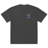 Front view of an oversized tee in faded black. A small graphic sits high on the left chest: a loose, hand-drawn halo ring in white tilted above a sharp six-pointed star in soft violet. Both shapes print flat, the ring's brushed edges left rough and unfinished.