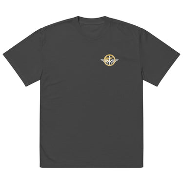 Front view of an oversized tee in Faded Black. A small circular emblem sits on the left chest: a gold ring lettered "MIRACULUM IN CAELO NUMQUAM CADET" in white capitals, with a white winged spearhead standing through its centre and swept wings running out to either side.