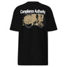 Back view of an t-shirt in black. A large graphic composition spans the upper back, featuring the phrase “Compliance Authority” in bold at the top, with a date range centered beneath it. Below, a rectangular collage combines a textured illustration of a dial-like object and a stylized figure, framed by vertical bars with additional characters. Thin linework of symmetrical wings extends outward from the bottom edge of the collage, adding contrast to the overall layered design.