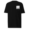 Front view of a t-shirt in black. A small halftoned panel sits on the left chest: a bare, leafless tree standing over dark undergrowth, printed with a woven fabric texture and rough torn edges. Below it the words "pas seul" are set in a fine serif, the letters scattered and stepping down to the right.