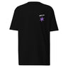 Front view of a t-shirt in black. A small graphic sits high on the left chest: a loose, hand-drawn halo ring in white tilted above a sharp six-pointed star in soft violet. Both shapes print flat, the ring's brushed edges left rough and unfinished.