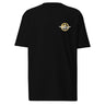 Front view of a t-shirt in Black. A small circular emblem sits on the left chest: a gold ring lettered "MIRACULUM IN CAELO NUMQUAM CADET" in white capitals, with a white winged spearhead standing through its centre and swept wings running out to either side.