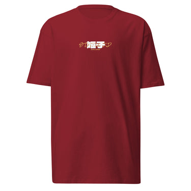 Front view of a T-Shirt in Brick Red. a small chest graphic pairing a gold cursive wordmark partially overlaid by a bold white stylized emblem, with a block-letter word underneath in the same gold tone