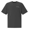 Front view of an oversized tee in black. Design features a small, minimal text print placed on the upper left chest. The word “demiurge” appears in a clean serif font, preceded by a small infinity-shaped symbol. Just beneath it, in tiny handwritten script, the phrase “the mind” is printed in quotation marks.