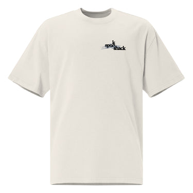 Front view of an oversized tee in white. Design features a small logo on the upper chest featuring the words "spook shack" in a stacked, stylized font, with abstract horizontal brush strokes layered behind the text.