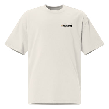 Front view of an oversized tee in faded bone. A minimalist design is placed on the upper left chest, featuring a compact arrangement of graphic elements. The word “KRAMPUS” appears in small white uppercase lettering, paired with a circular gold icon to its left. 
