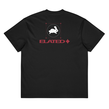 Back view of a box tee in black, flat. A white rabbit silhouette runs within a circle, framed by a square with red corner bracket markers. Below, bold text reads "ELATED♦" in deep crimson — clean, geometric, and expressive.
