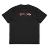 Front view of a box tee in black, flat. A graphic centered on the chest features the letters of the word "SPARKLE" stylized and scattered among abstract shapes, a line drawing of a mask, and small blocks of text.