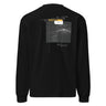 Back view of an longsleeve in black. Design shows a rectangular grayscale graphic centered on the upper back showing a lighthouse shining into darkness. Above the image is a yellow label reading “LIGHTKEEPER,” surrounded by thin white grid lines and handwritten script text for a technical, conceptual design aesthetic