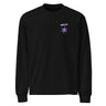 Front view of a longsleeve in black. A small graphic sits high on the left chest: a loose, hand-drawn halo ring in white tilted above a sharp six-pointed star in soft violet. Both shapes print flat, the ring's brushed edges left rough and unfinished.