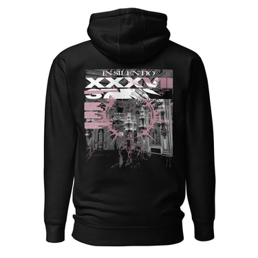 Back view of a hoodie in black. A large rectangular back graphic layers an ornate hall interior in high-contrast greyscale beneath oversized roman numerals 'XXXVII' and a serif 'IN SILENTIO' wordmark. Dusty pink text bars carry a short poem down the left edge, cut through by thorned starburst linework in the same pink.