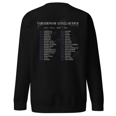 Back view of a sweatshirt in black. A large graphic fills the upper back, laid out like a concert tour poster. A wide display serif title reads "VARIATIONS OF A STELLAR TOUR" in white, with a small italic "robin" and "/summeretto" tucked beneath it and a ruled row of four era markers below that. Two columns of dated stops run down the rest in condensed capitals, the dates set in violet, with thin outlined starbursts drifting across the list.