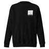Front view of a sweatshirt in black. A small halftoned panel sits on the left chest: a bare, leafless tree standing over dark undergrowth, printed with a woven fabric texture and rough torn edges. Below it the words "pas seul" are set in a fine serif, the letters scattered and stepping down to the right.
