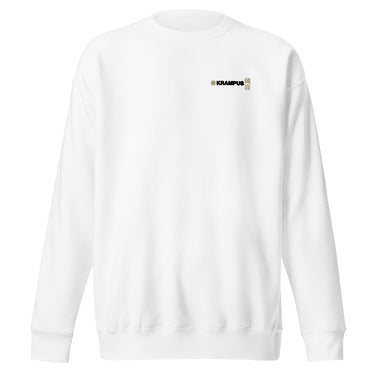 Front view of an sweatshirt in white. A minimalist design placed on the upper left chest shows a compact arrangement of small graphic elements, including a circular icon, the word “KRAMPUS” in bold, and a narrow vertical block with stylized symbols.
