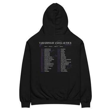 Back view of an oversized hoodie in black. A large graphic fills the upper back, laid out like a concert tour poster. A wide display serif title reads "VARIATIONS OF A STELLAR TOUR" in white, with a small italic "robin" and "/summeretto" tucked beneath it and a ruled row of four era markers below that. Two columns of dated stops run down the rest in condensed capitals, the dates set in violet, with thin outlined starbursts drifting across the list.