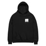 Front view of an oversized hoodie in black. A small halftoned panel sits on the left chest: a bare, leafless tree standing over dark undergrowth, printed with a woven fabric texture and rough torn edges. Below it the words "pas seul" are set in a fine serif, the letters scattered and stepping down to the right.