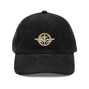 Front view of a corduroy cap in Black. A circular emblem is embroidered on the front panel: a gold ring lettered "MIRACULUM IN CAELO NUMQUAM CADET" in white stitching, with a white winged spearhead standing through its centre and swept wings running out to either side. Unstructured six-panel corduroy crown, curved brim, metal buckle.