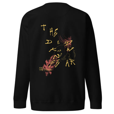 Back view of a solid-colored sweatshirt. A large collage graphic on the upper back features the scattered, handwritten-style text "THE DEAD KNOW NO FEAR", layered over a fine-line character illustration and an abstract textured shape.