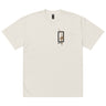 Front view of a solid-colored oversized-tee. A small graphic on the chest features a vertical rectangular frame containing a high-contrast floral illustration and a sword-like shape.