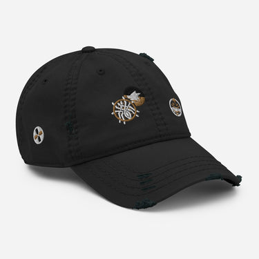 A three-quarter view of a solid-colored, distressed hat, showing three different embroidered circular emblems with abstract patterns on the front and side.